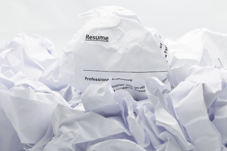 Crumpled up resume on a pile of paper trash